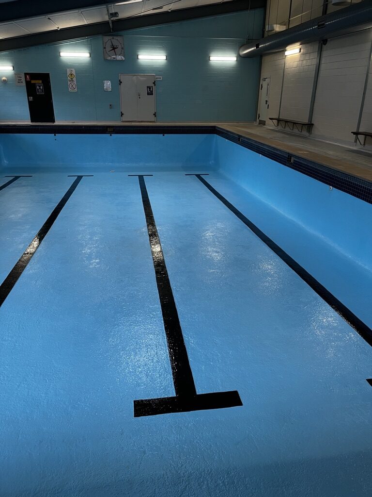 Finished commercial lap pool with fresh blue epoxy coating