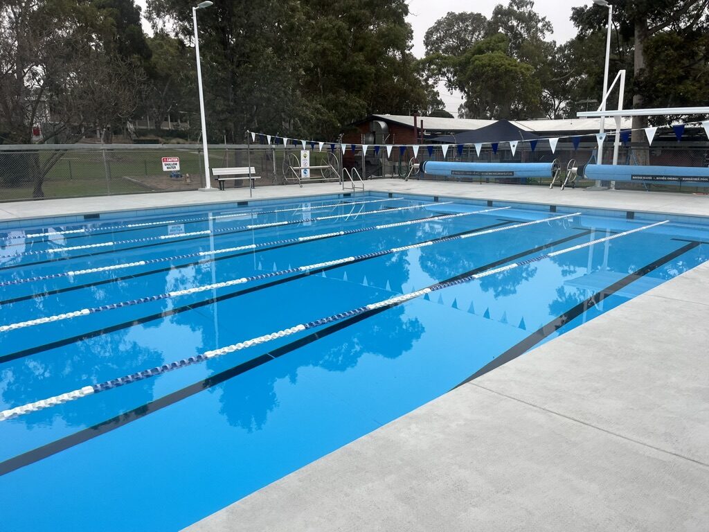 Finished commercial lap pool filled with water, lane ropes and flags