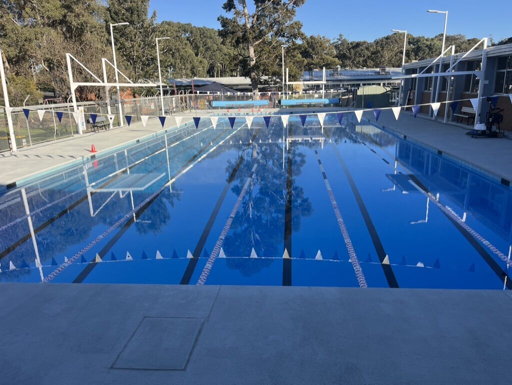 Finished commercial lap pool filled with water, lane ropes and flags