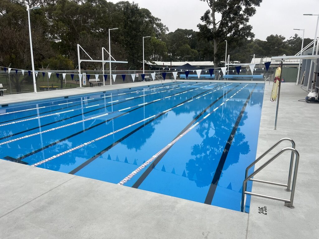 Finished commercial lap pool filled with water, lane ropes