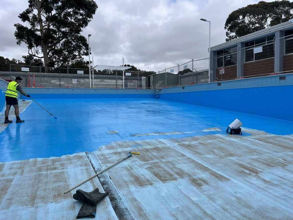 Applying epoxy coating to a drained commercial lap pool