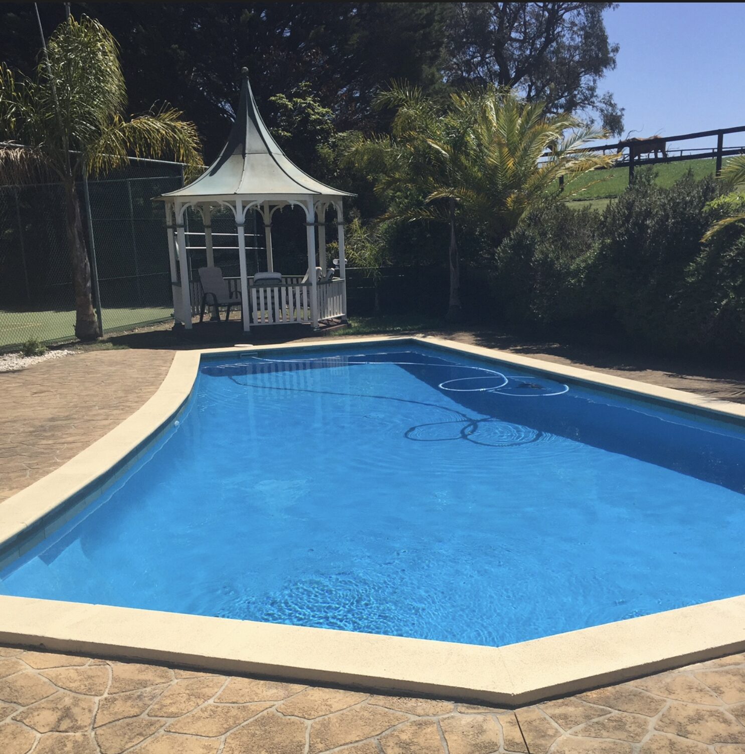 Resort-style pool with cream coping and stencilled paving on an acreage property