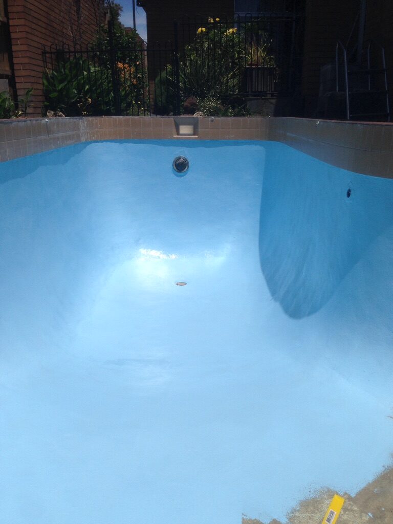 Finished residential pool corner with blue epoxy coating
