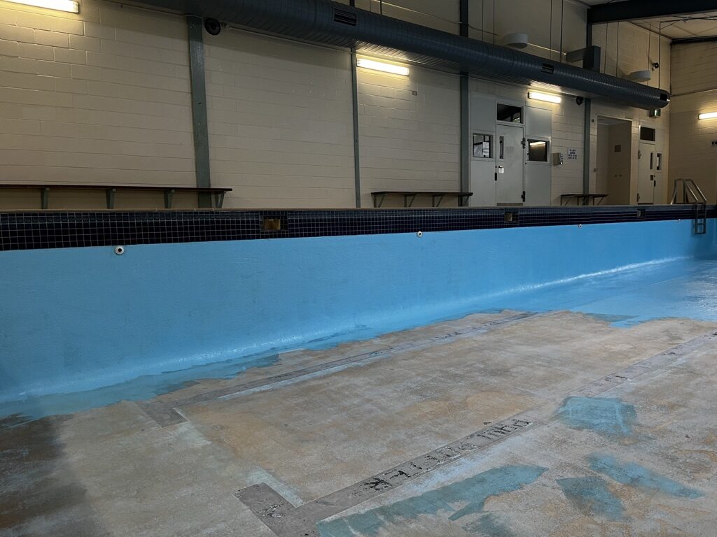 Close-up of epoxy coating being applied to a pool wall